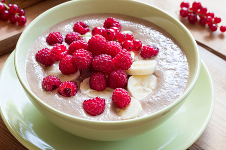 Summer breakfast - raw breakfast bowl with raspberries and red currantsの写真素材