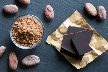 Raw unroasted cocoa powder, whole raw cacao nibs, and chocolateの写真素材