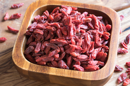 Dried goji berries in a wooden bowlの写真素材