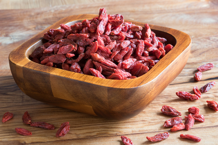 Dried goji berries in a wooden bowlの写真素材