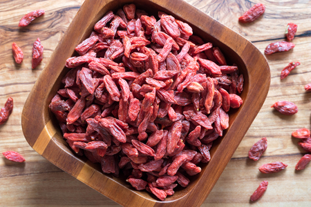 Dried goji berries in a wooden bowlの写真素材
