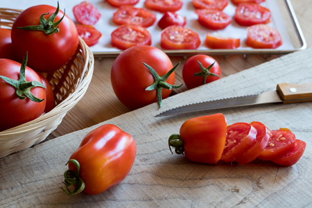 Preparation of dried tomatoes - slicing San Marzano tomatoes on a cutting boardの写真素材