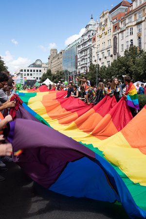 PRAGUE, CZECH REPUBLIC - AUGUST 12, 2017: People participating in Prague Pride, a big gay & lesbian pride, unfold a giant rainbow flag at the Wenceslas squareのeditorial素材