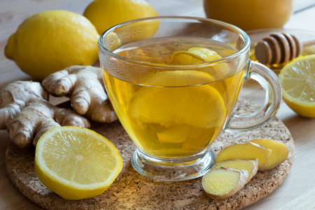 Ginger tea with lemon, honey and fresh ginger root in the backgroundの写真素材