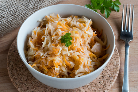 Fermented cabbage and carrots in a bowl on a tableの写真素材