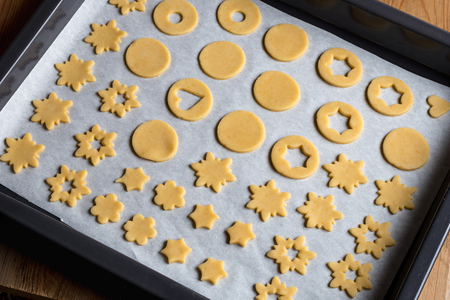 Preparation of traditional Linzer Christmas cookies - cut out shapes on a baking sheet before bakingの写真素材