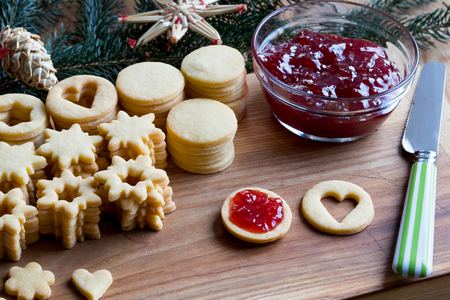 Filling traditional Linzer Christmas cookies with strawberry jamの写真素材