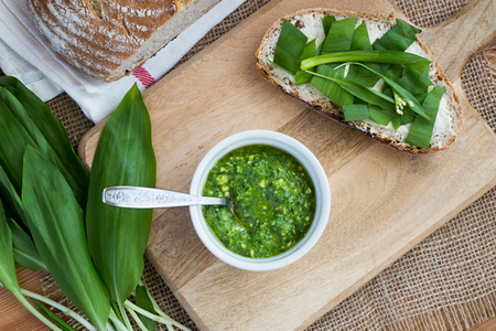 Homemade wild garlic pesto, and a slice of sourdough bread with butter and wild garlicの写真素材