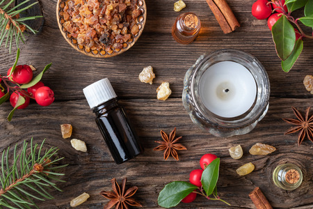 Bottles of essential oil on a Christmas background with frankincense, myrrh, wintergreen and winter spicesの写真素材