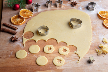 Cutting out shapes from rolled out dough to prepare traditional Linzer Christmas cookiesの写真素材