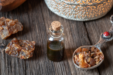 A bottle of essential oil with myrrh resin crystals and an aroma lampの写真素材