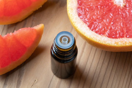 A bottle of citrus essential oil with fresh grapefruitの写真素材