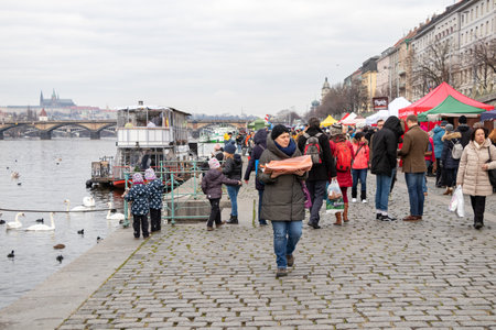 PRAGUE, CZECH REPUBLIC - DECEMBER 16, 2017: People at the popular farmers market at the Naplavka riverbank, with Prague Castle in the backgroundのeditorial素材