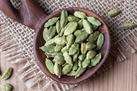 Cardamon seeds on a wooden spoon, top viewの写真素材