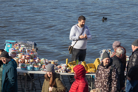 PRAGUE, CZECH REPUBLIC - FEBRUARY 16, 2019: Man selling pottery and candles at the popular farmers market at the Naplavka riverbankのeditorial素材