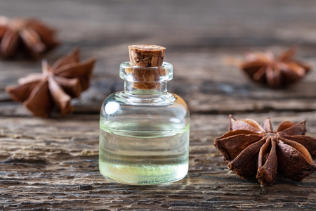 A bottle of essential oil with star anise on a rustic backgroundの写真素材