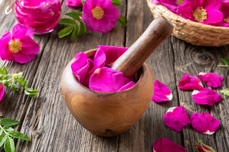 Fresh Rugosa rose petals in a wooden mortarの写真素材