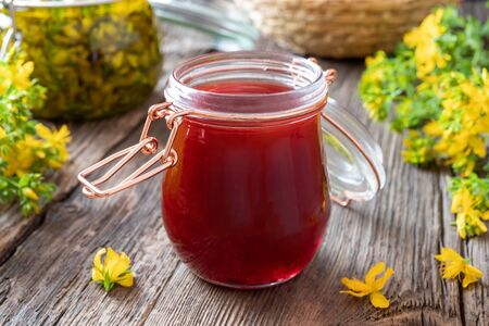 A jar of red oil made from St. John's wort flowersの写真素材