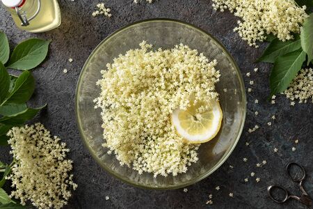 Macerating elder flowers and lemon in water, to prepare homemade herbal syrup. Top view