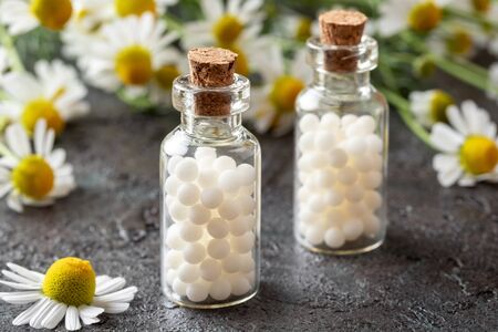 Bottles of homeopathic remedies with fresh chamomile flowersの写真素材