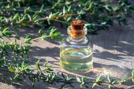 A bottle of essential oil with thyme twigsの写真素材