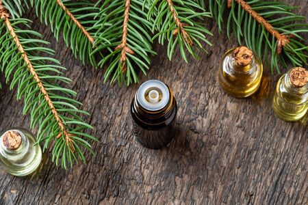 Bottles of essential oil with fresh spruce branchesの写真素材