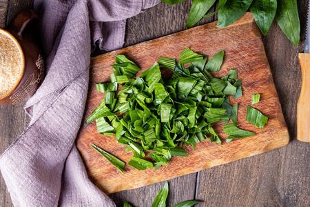 Cut up ribwort plantain leaves on a table - preparation of herbal syrupの写真素材