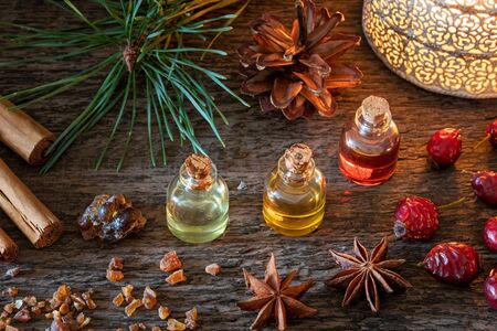 Christmas selection of essential oils with frankincense, myrrh, cinnamon, star anise and dried rose...