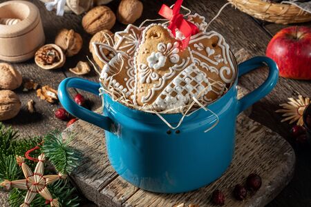 Handmade Christmas gingerbread cookies in a blue pot on a wooden tableの写真素材
