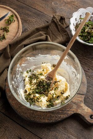 Mixing butter and minced young nettles to prepare a spreadの写真素材