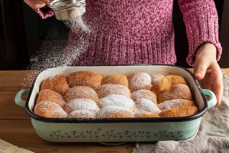 Buchty, typical Czech sweet buns made of yeast dough - dusting with sugar