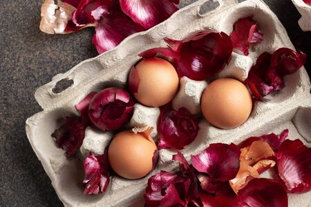 Raw eggs in a carton, ready to be dyed with onion skins