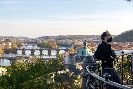 PRAGUE, CZECH REPUBLIC - APRIL 16, 2020: Tourist in face mask visiting the city during the coronavirus pandemicのeditorial素材