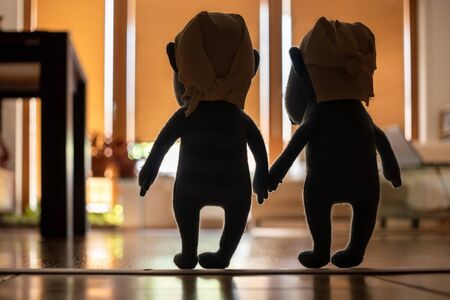 Silhouettes of two characters walking around in an empty appartmentの写真素材