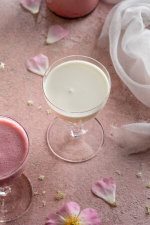 A glass of goats milk kefir on a pink backgroundの写真素材