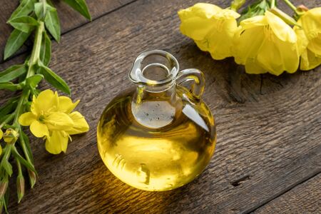 A bottle of evening primrose oil with fresh blooming Oenothera biennis plant の写真素材