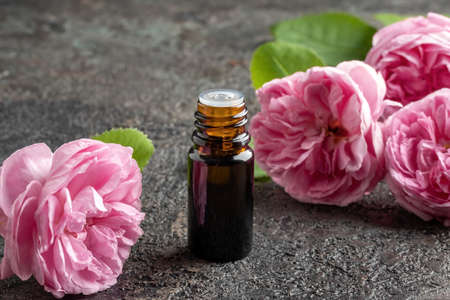 A dropper bottle of essential oil with fresh rose de mai flowersの写真素材