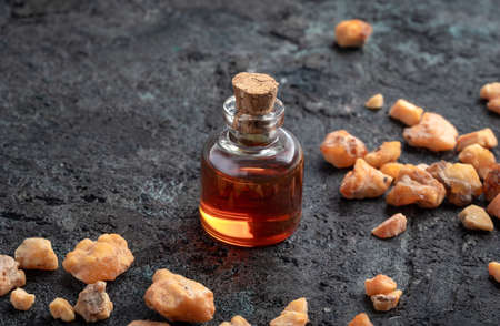 A bottle of styrax benzoin essential oil on a dark backgroundの写真素材