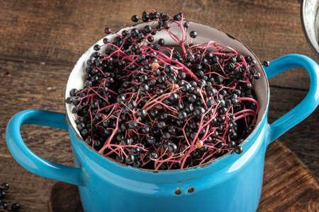 Black elder berries in a pot on a table