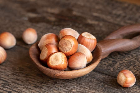 Hazelnuts on a wooden spoon on a table