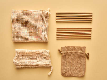 Mesh bags made of organic cotton, linen sac, bamboo and paper straws - ecological zero-waste concept on yellow backgroundの写真素材