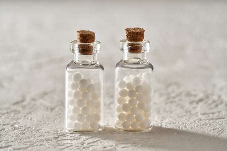Two bottles of homeopathic pills on white background