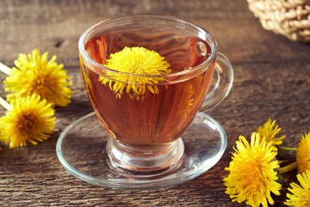 A cup of dandelion tea on a rustic tableの写真素材