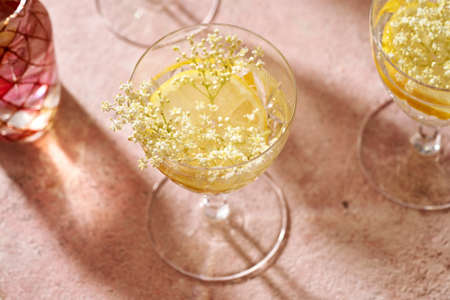 A glass of homemade herbal elder flower lemonade on pink backgroundの写真素材