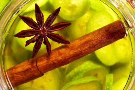Star anise and Ceylon cinnamon - spices macerating with unripe sliced walnuts, to prepare homemade nut liqueur or tinctureの写真素材