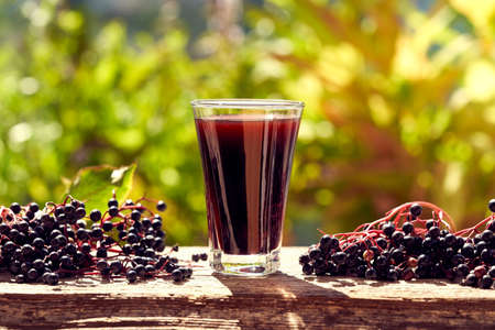 A glass of black elderberry syrup - alternative herbal remedyの写真素材