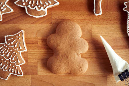 Decoration of homemade gingerbread Christmas cookies with white icing using a cornetの写真素材