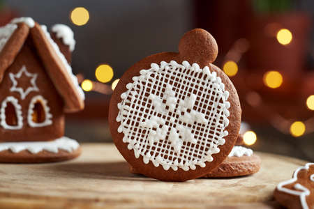 Homemade Christmas gingerbread cookie with a house and bokeh in the backgroundの写真素材