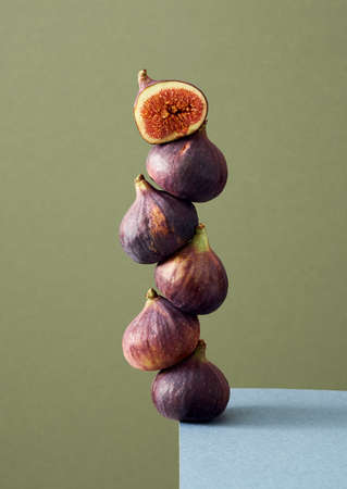 Fresh figs balancing on the edge of a tableの写真素材