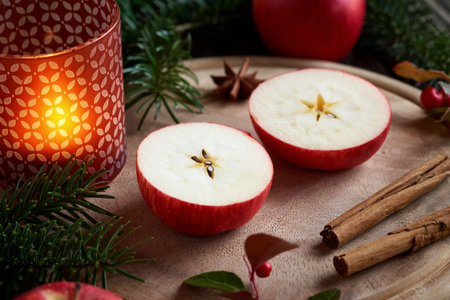 Christmas decoration with an apple cut in two halves with a star in the middle, with cinnamon, wintergreen and firの写真素材